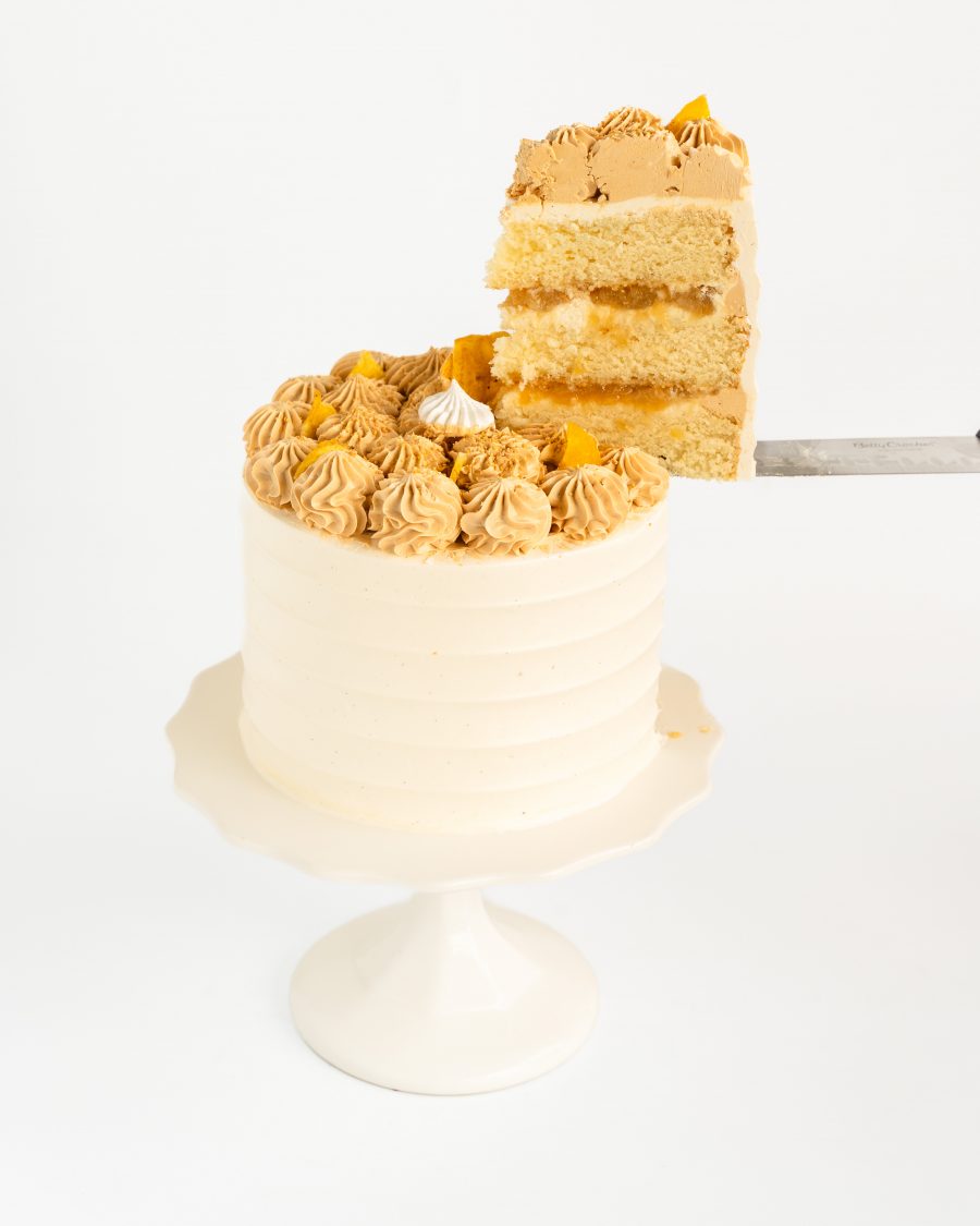 Close-up of caramel banana cream cake topped with dulce de leche buttercream and banana chips