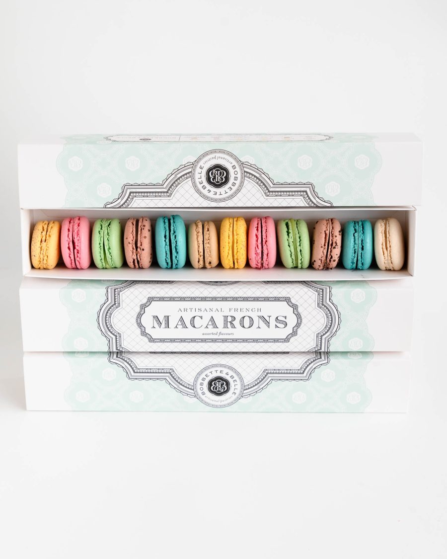 Box of 12 assorted French macarons in pastel colours in elegant packaging on a clean background
